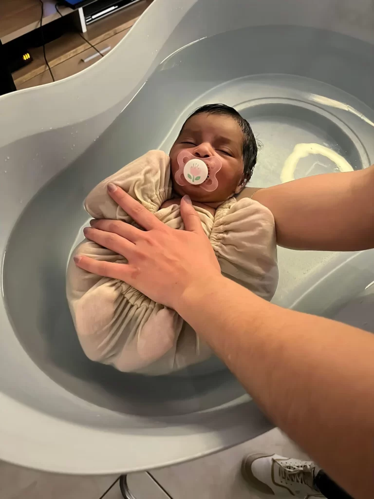 Bain sensoriel pour bébé enveloppé dans un lange